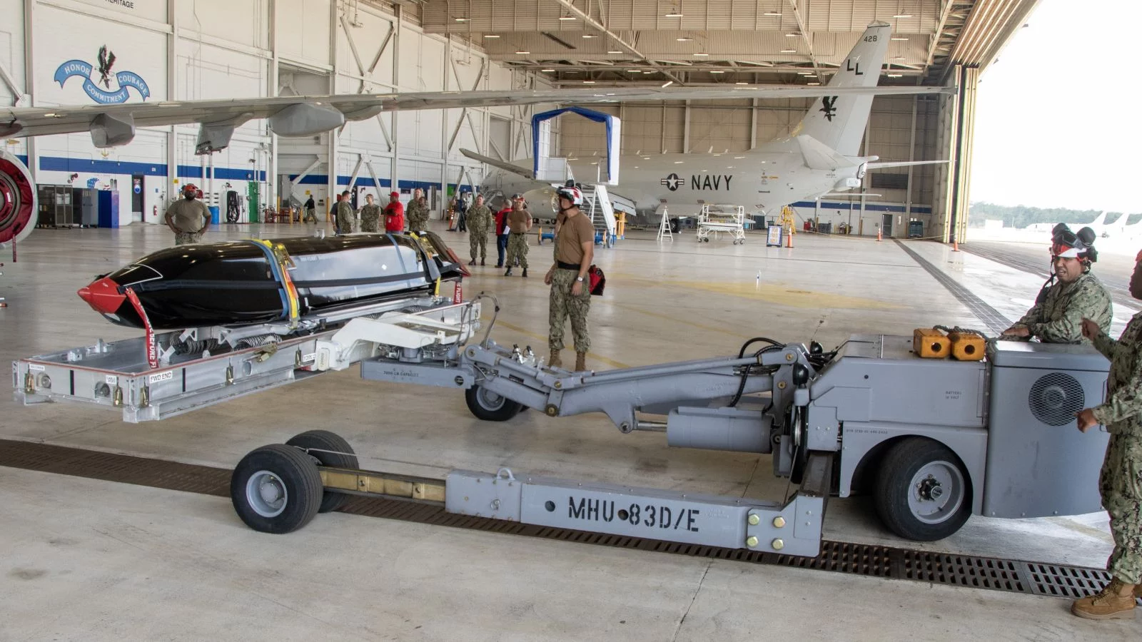 Personal de la Marina transporta un misil AGM-158C LRASM para instalarlo en un P-8A Poseidon.