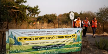 Personal médico pasa junto a una señal que prohíbe el acceso a excursionistas cerca del lugar de una explosión en las afueras de Yiftah, en el norte de Israel, el 12 de octubre de 2026.