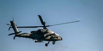 Un helicóptero AH-64 Apache estadounidense dispara su cañón de 30 mm durante Skyfall II, con un radar AN/MPQ-64 Sentinel en primer plano, en Grafenwoehr, Alemania, el 6 de octubre de 2026.