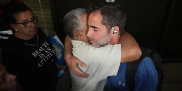 El pasajero israelí Asaf Rajuan abraza a otro pasajero del vuelo de flydubai al llegar al aeropuerto Ben Gurion el 30 de septiembre de 2026.