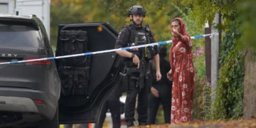 Un policía armado conversa con una persona cerca de la sinagoga de Heaton Park, en Crumpsall, Mánchester, el 2 de octubre de 2025.