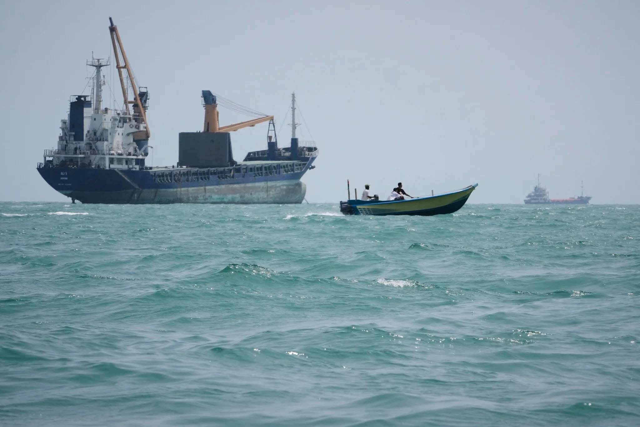 Una lancha pasa junto a un buque mercante fondeado en el estrecho de Ormuz, frente a Bandar Abbas, el 6 de septiembre de 2026.