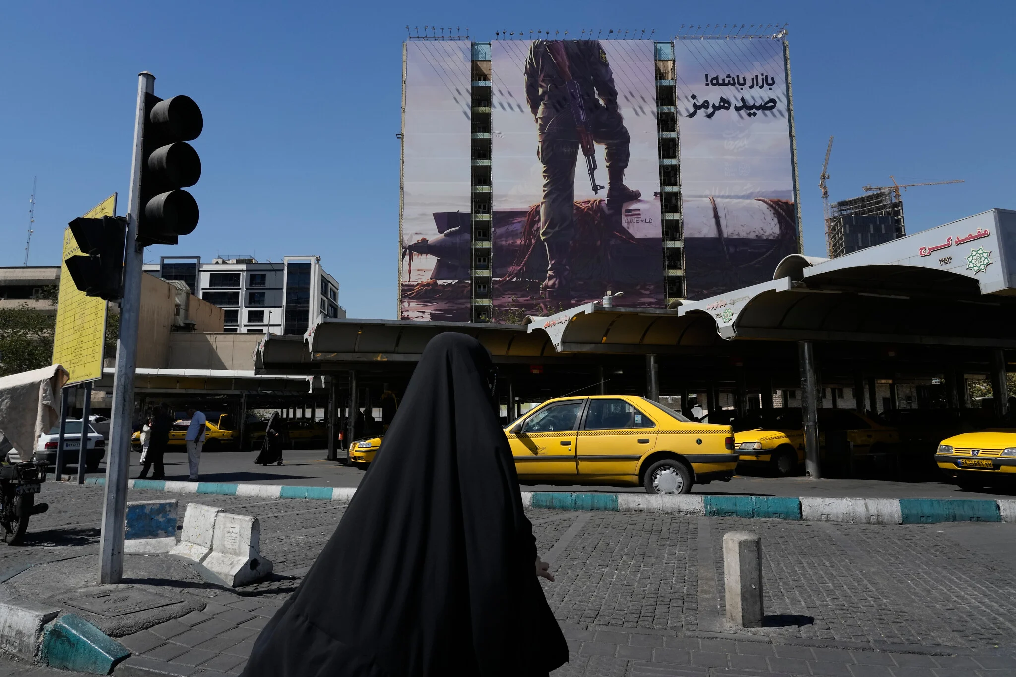 Una mujer pasa junto a un cartel de la Guardia Revolucionaria de Irán en una plaza del norte de Teherán.