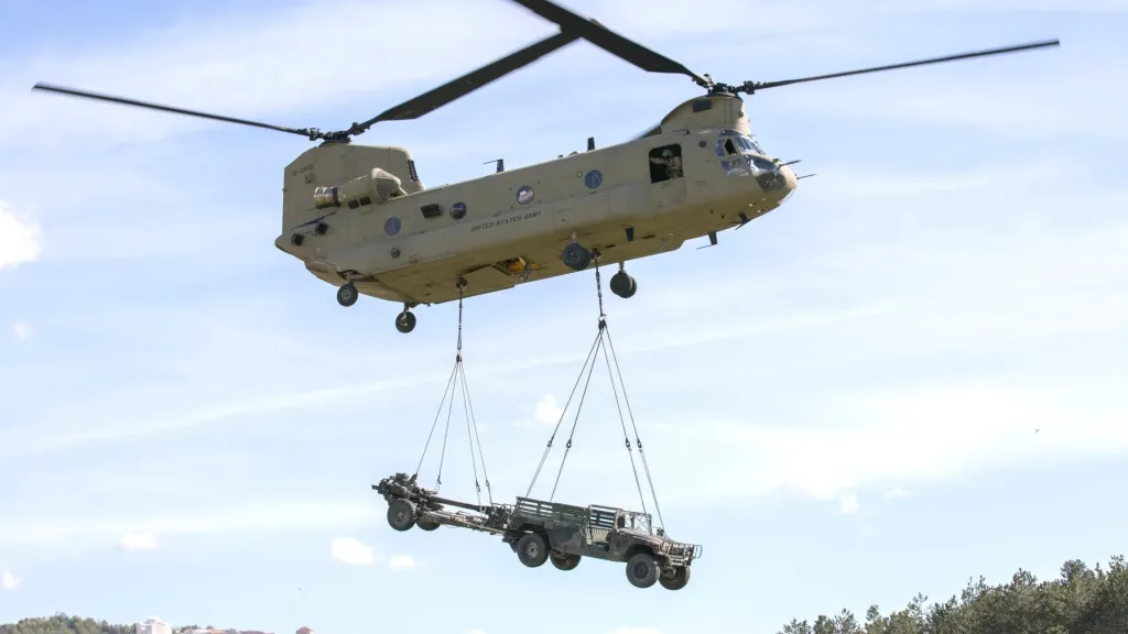 Helicóptero CH-47 Chinook con un Humvee y un obús M119 de 105 mm en carga externa.