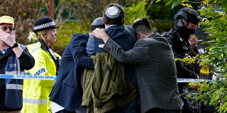 Miembros de la comunidad judía se consuelan tras el atentado mortal del 2 de octubre de 2025 en la sinagoga Heaton Park de Manchester.
