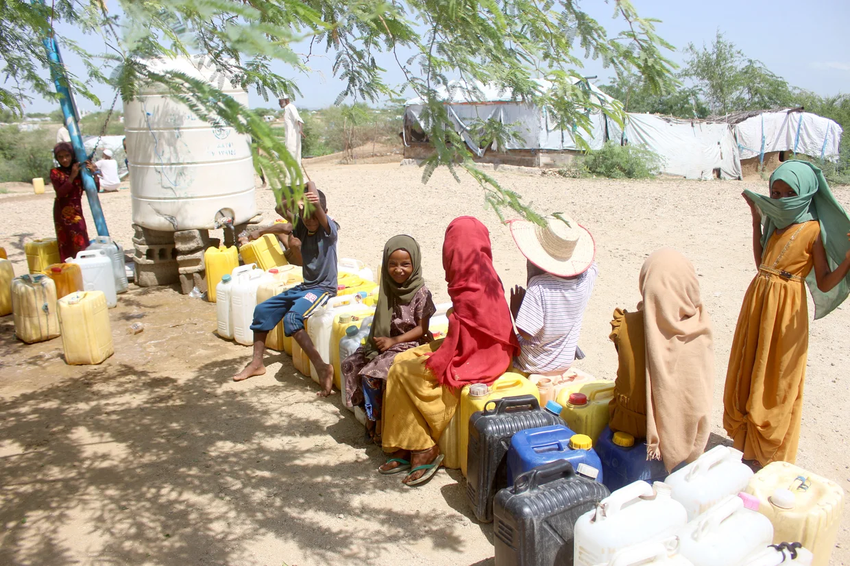 Personas desplazadas esperan agua en Yemen Yemeníes desplazados esperan para llenar recipientes de agua en la gobernación de Hajjah