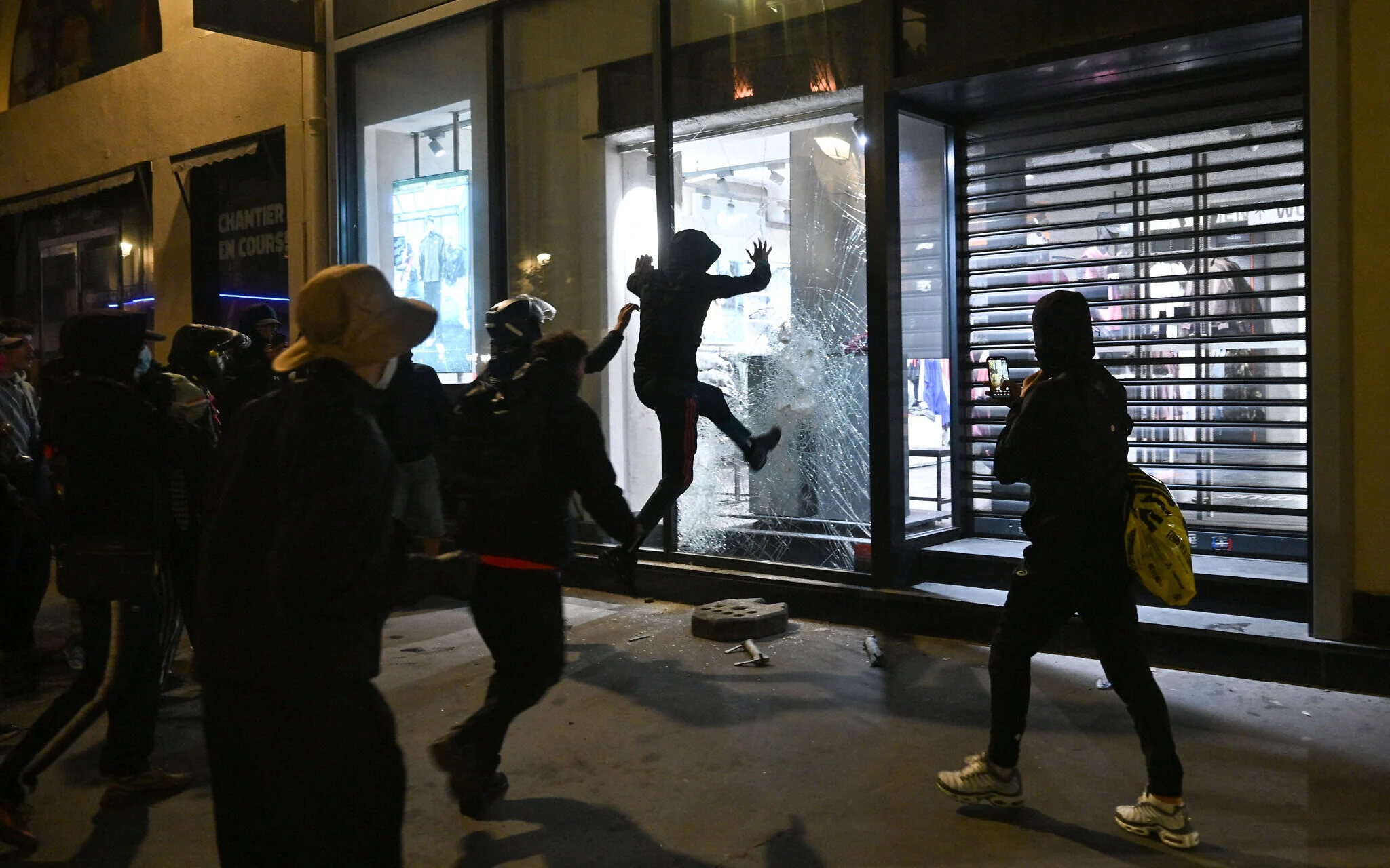 Personas intentan romper el escaparate de una tienda Snipes cerca de Châtelet-Les Halles, en París.