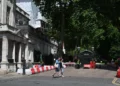 People walk past the gated entrance to the road housing the Israeli embassy in London on June 15, 2025. (Justin Tallis/AFP)