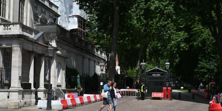 People walk past the gated entrance to the road housing the Israeli embassy in London on June 15, 2025. (Justin Tallis/AFP)