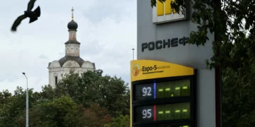 Un ave vuela cerca de un cartel de precios en una gasolinera de Rosneft en Moscú, el 14 de agosto de 2026, durante una escasez de combustible tras ataques ucranianos a refinerías rusas.