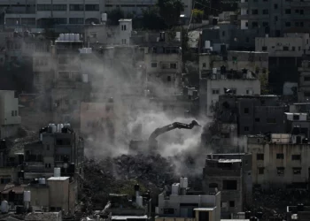 An Israeli army bulldozer demolishes homes in the Palestinian urban refugee camp of Nur Shams, near the West Bank city of Tulkarem, December 31, 2025. (AP/Majdi Mohammed)