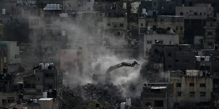 An Israeli army bulldozer demolishes homes in the Palestinian urban refugee camp of Nur Shams, near the West Bank city of Tulkarem, December 31, 2025. (AP/Majdi Mohammed)