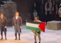El cantante Gabriel Sanchez-Ortega sostiene una bandera palestina durante los saludos finales de «Tosca» en la Ópera de Calgary, el 16 de octubre de 2026.