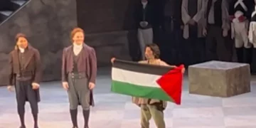 El cantante Gabriel Sanchez-Ortega sostiene una bandera palestina durante los saludos finales de «Tosca» en la Ópera de Calgary, el 16 de octubre de 2026.