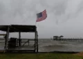 A US flag flaps in the wind generated by Hurricane Isaias on an empty beach on Mon Louis Island, Alabama, on October 9, 2026 (AP Photo/Octavio Jones)