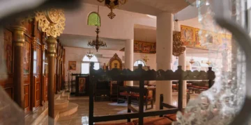Interior de una iglesia ortodoxa griega visto a través de una ventana rota tras el ataque durante un funeral en Hammoud, Karak, el 23 de octubre de 2026