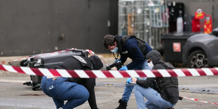 Agentes de policía examinan indicios en una gasolinera de Trappes, cerca de París, tras un ataque a tiros.