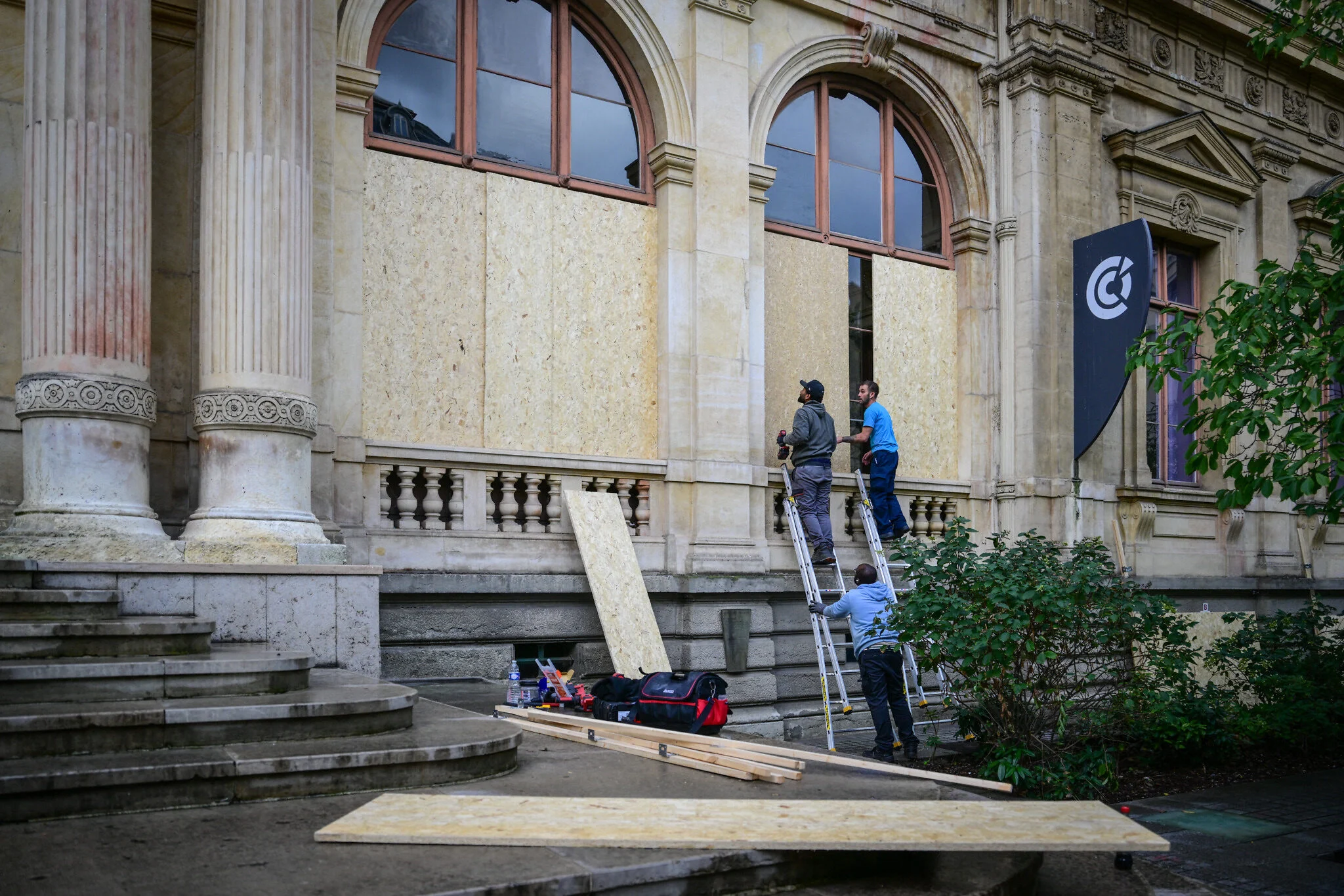 Protección de edificios antes de las protestas en Lyon Trabajadores colocan tablones de madera en las ventanas de la Cámara de Comercio e Industria de Lyon el 23 de octubre de 2026.