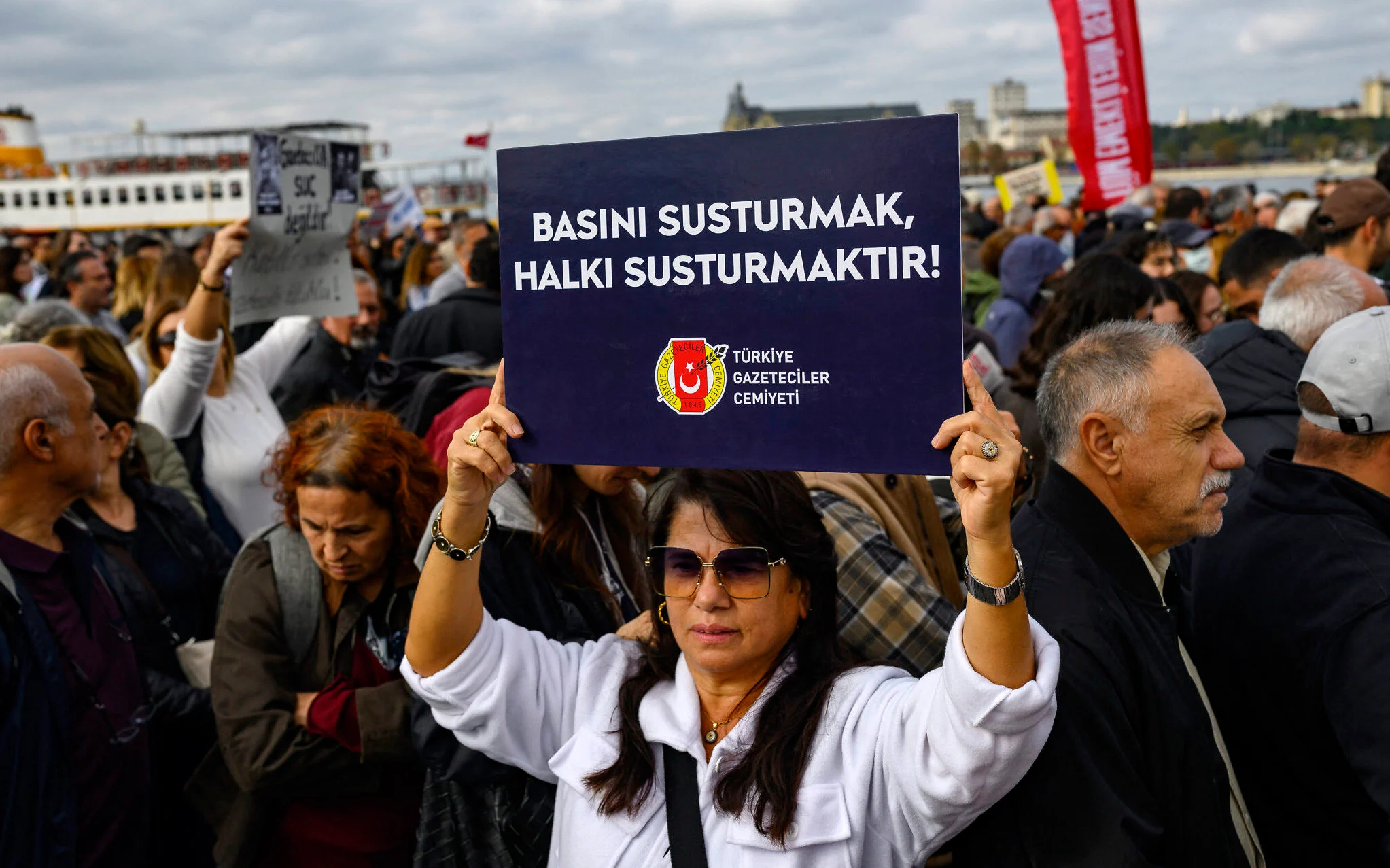 Manifestante sostiene un cartel que dice «Silenciar a la prensa es silenciar al pueblo» durante una protesta en Estambul.
