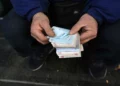 Un cambista callejero cuenta billetes iraníes en un distrito comercial del centro de Teherán, Irán, el 23 de diciembre de 2022, sin mostrar el rostro.