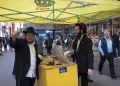 Shmuel Cohen (a la izquierda) hace una pausa en su labor de ayudar a transeúntes a colocarse tefilín en el Distrito de los Diamantes de Nueva York, el 23 de octubre de 2026.