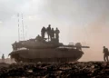 Soldados de las FDI sobre un tanque en un campo cerca del kibutz Be'eri, en el sur de Israel, el 14 de octubre de 2023.