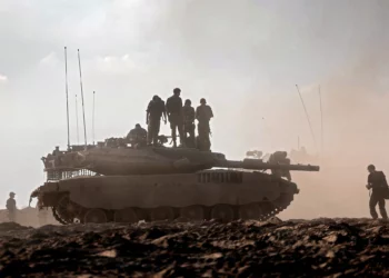 Soldados de las FDI sobre un tanque en un campo cerca del kibutz Be'eri, en el sur de Israel, el 14 de octubre de 2023.