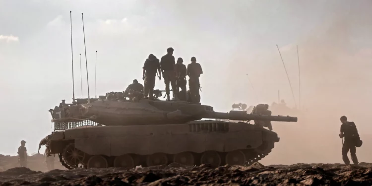 Soldados de las FDI sobre un tanque en un campo cerca del kibutz Be'eri, en el sur de Israel, el 14 de octubre de 2023.