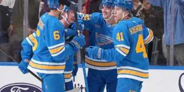 Justin Barron, de los St. Louis Blues, recibe las felicitaciones de Philip Broberg y Aleksanteri Kaskimaki tras marcar un gol contra los Vegas Golden Knights.