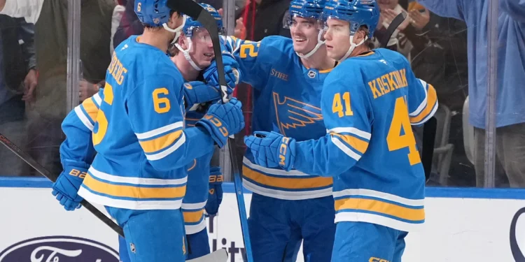 Justin Barron, de los St. Louis Blues, recibe las felicitaciones de Philip Broberg y Aleksanteri Kaskimaki tras marcar un gol contra los Vegas Golden Knights.