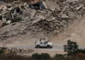 Un vehículo blindado de la Fuerza Provisional de las Naciones Unidas en el Líbano pasa junto a edificios destruidos en el sur del país el 22 de julio de 2026.