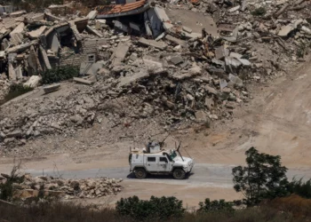 Un vehículo blindado de la Fuerza Provisional de las Naciones Unidas en el Líbano pasa junto a edificios destruidos en el sur del país el 22 de julio de 2026.