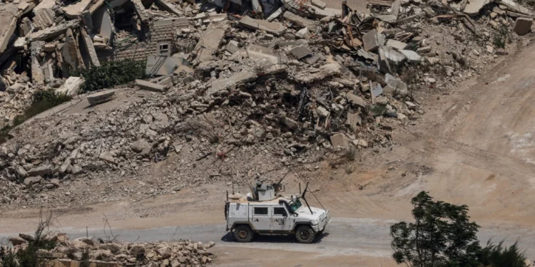 Un vehículo blindado de la Fuerza Provisional de las Naciones Unidas en el Líbano pasa junto a edificios destruidos en el sur del país el 22 de julio de 2026.