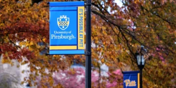 Banderolas en el campus de la Universidad de Pittsburgh entre árboles otoñales, el 10 de noviembre de 2025.