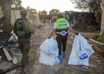 Voluntarios de ZAKA recorren la destrucción causada por terroristas de Hamas en el kibutz Kfar Aza y recogen cadáveres, el 15 de octubre de 2023.