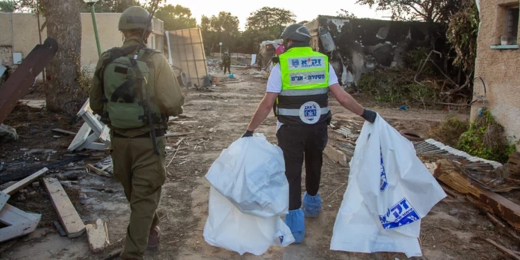 Voluntarios de ZAKA recorren la destrucción causada por terroristas de Hamas en el kibutz Kfar Aza y recogen cadáveres, el 15 de octubre de 2023.