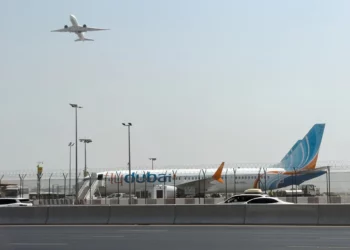 A plane takes off as a flydubai aircraft sits on the tarmac at Dubai International Airport in Dubai, United Arab Emirates, September 30, 2026. (AP Photo)