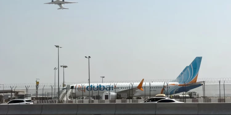 A plane takes off as a flydubai aircraft sits on the tarmac at Dubai International Airport in Dubai, United Arab Emirates, September 30, 2026. (AP Photo)